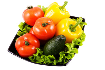 fresh vegetables for salad in black bowl on white