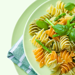 Colorful pasta with asparagus, rocket pesto and basil