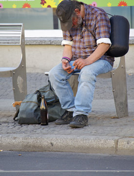 Alkoholiker auf einer Bank sitzend schlafend