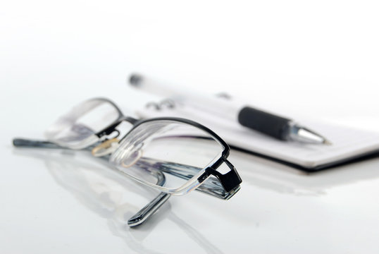 glasses,pen with notebook