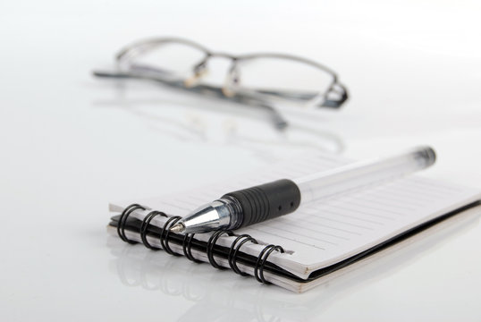 glasses,pen with notebook