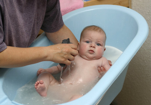 Kleinkind wird in Wanne gebaden