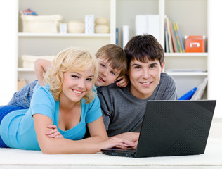 Fototapeta na wymiar Smiling family using laptop