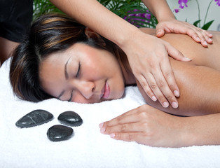 Obraz na płótnie Canvas Young Asian woman enjoying a back massage at spa