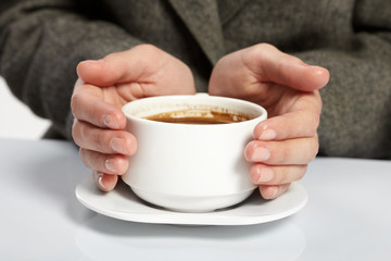 woman’s hands holding a cup of coffee