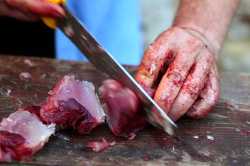 active fishmonger hand cutting tuna fish knife