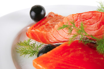 fresh smoked salmon on white plate with olives