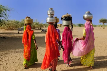 Wall murals India Ethnic women going for the water in well on the desert
