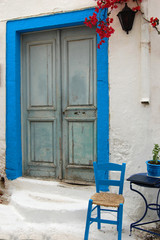 A chair and doorframe in the Greek blue and white color scheme