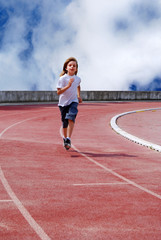 Enfant courant sur une piste d'athlétisme