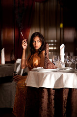 Attractive alone woman smoking cigarette at restaurant
