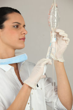 Portrait d'une infirmi&egrave;re faisant un perfusion