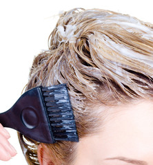 Fragment of woman's head coloring hair
