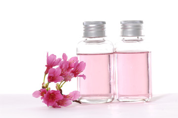 Spa concept -beautiful red flowers and spa liquid