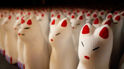 Fox shaped doll offerings at a shrine in Japan - obrazy, fototapety, plakaty