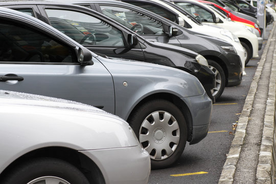 A Row Of Parked Cars Beside A Road