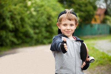 Boy showing thumbs up sign outdoors