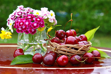 ein blumenstrauß und kirschen