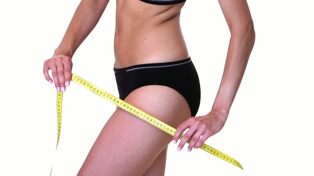 Body part of a fit woman with measure tape