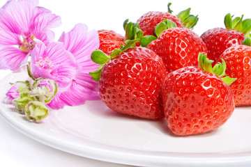 Strawberry on a plate decorated with malva flowers
