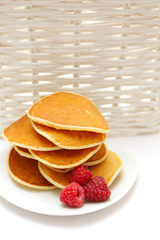 Small pancakes topped with berries isolated on white. Food backg