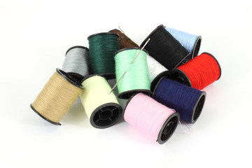Jumble of spools of thread and sewing needle