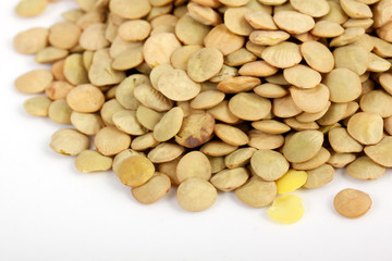 Lentil scattered on white background close up view