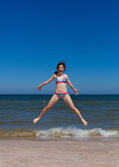 Girl jumping on beach
