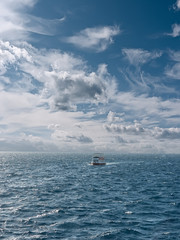 Seascape with boat and beautiful clouds.