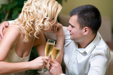Couple celebrating with champagne together, in a restaurant