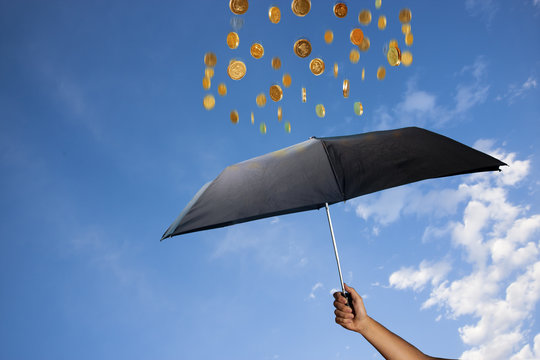 coins are raining over an umbrella