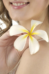 Obraz na płótnie Canvas Sexy model holding white frangipani