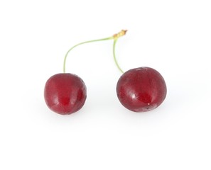 Two cherries on a white background