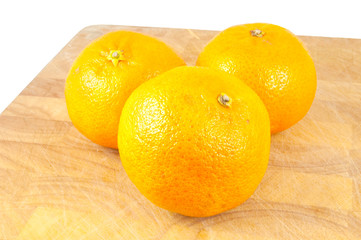 oranges on chopping board on white background