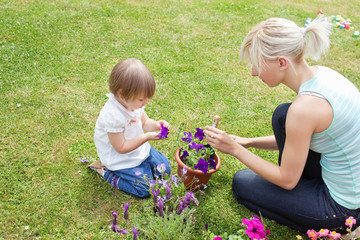 Blond Mother showing her daughter a purple flower