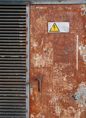 High voltage sign on a rusty door