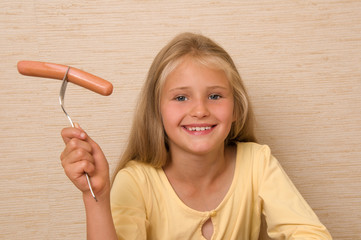 Little girl eating sausage