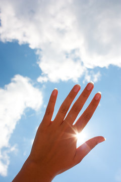 woman's hand against the sky