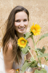 portrait d'une belle femme entre blé et tournesols