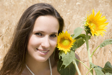 portrait d'une ravissante femme entre blé et tournesol