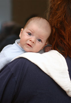 Baby liegt &uuml;ber der Schulter seiner Mutter
