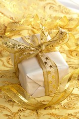 Fototapeta na wymiar Beautiful gift box on the gold background