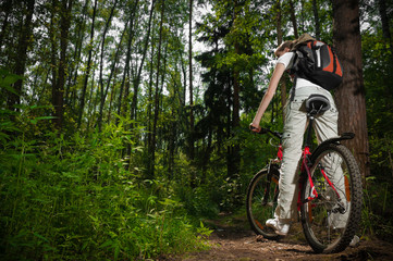 Fototapeta na wymiar young woman with bicycle in forest
