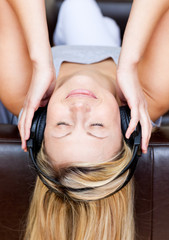 Sleeping woman lying on a sofa and listen to music