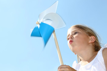 Closeup of little girl blowing blue wind wheel