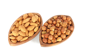 Two wooden bowls full of hazelnuts and almonds