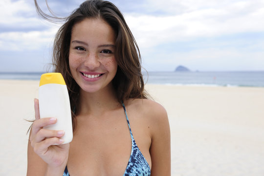 woman showing suncream at the beach