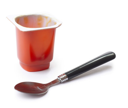 Empty yogurt pot and spoon over white