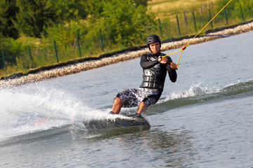 Junger Mann beim Wassersport Wakeboard Wasserski