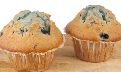 two muffins on chopping block isolated on white